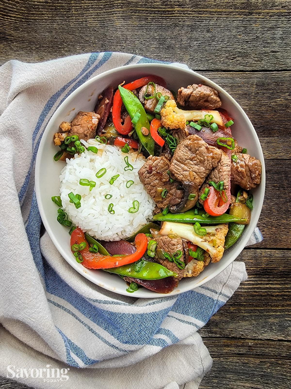 Mongolian beef stir-fry being served over rice