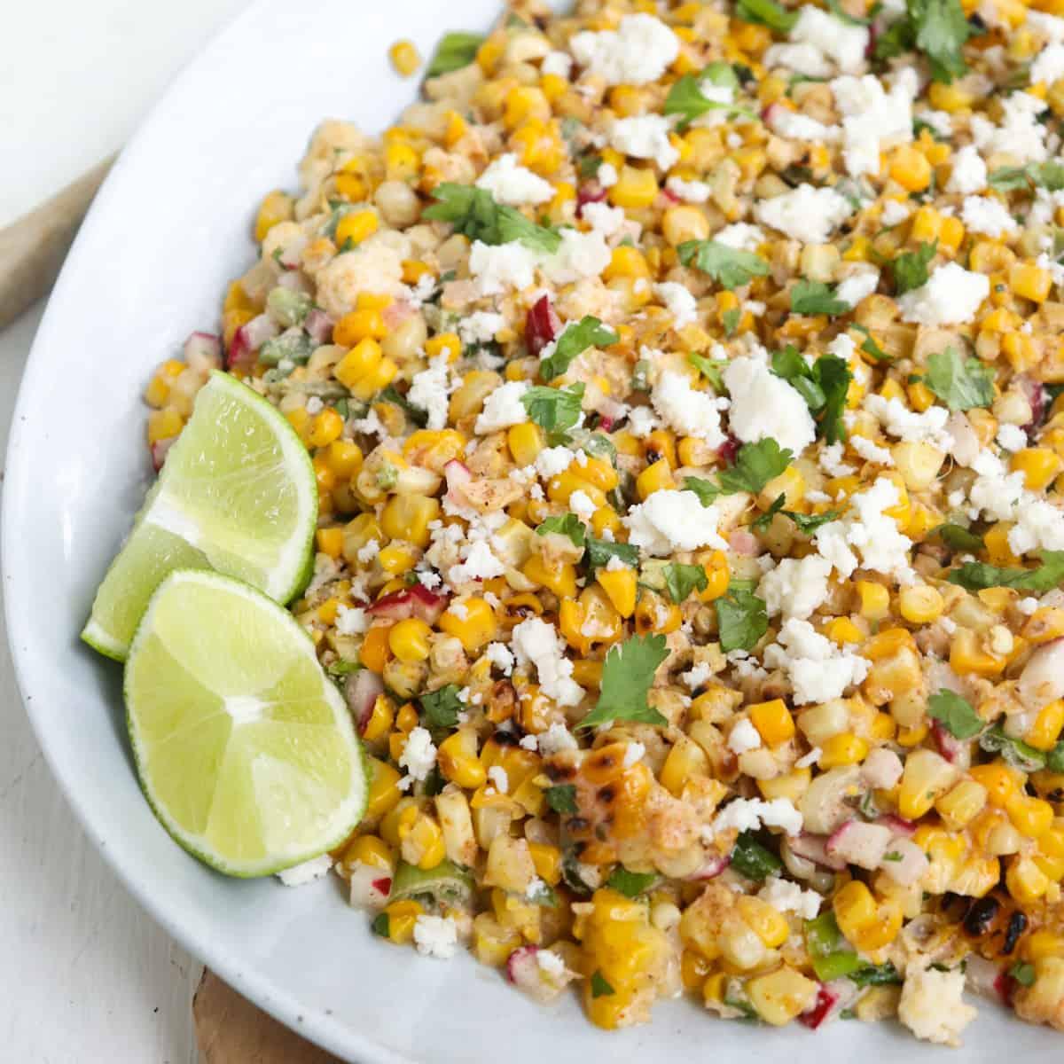 close up of elote salad with candied pecans in a colorful bowl