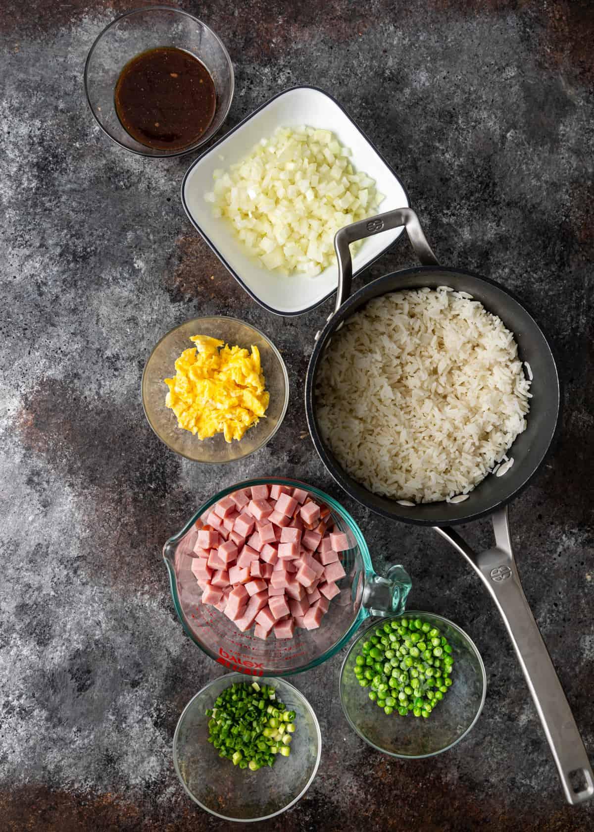 Ingredients for five-spice pulled pork fried rice laid out on a wooden table