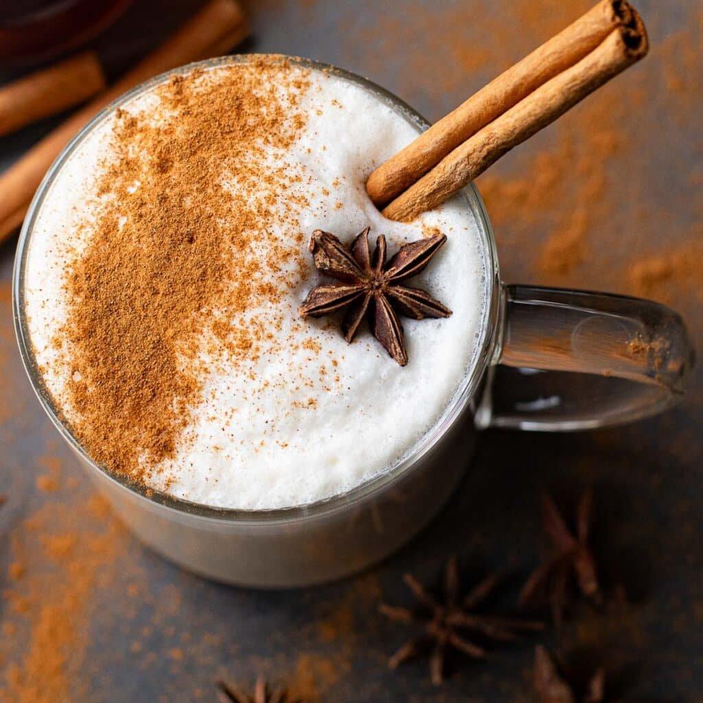 overhead shot of a steaming maple cinnamon chai latte with a cinnamon stick garnish