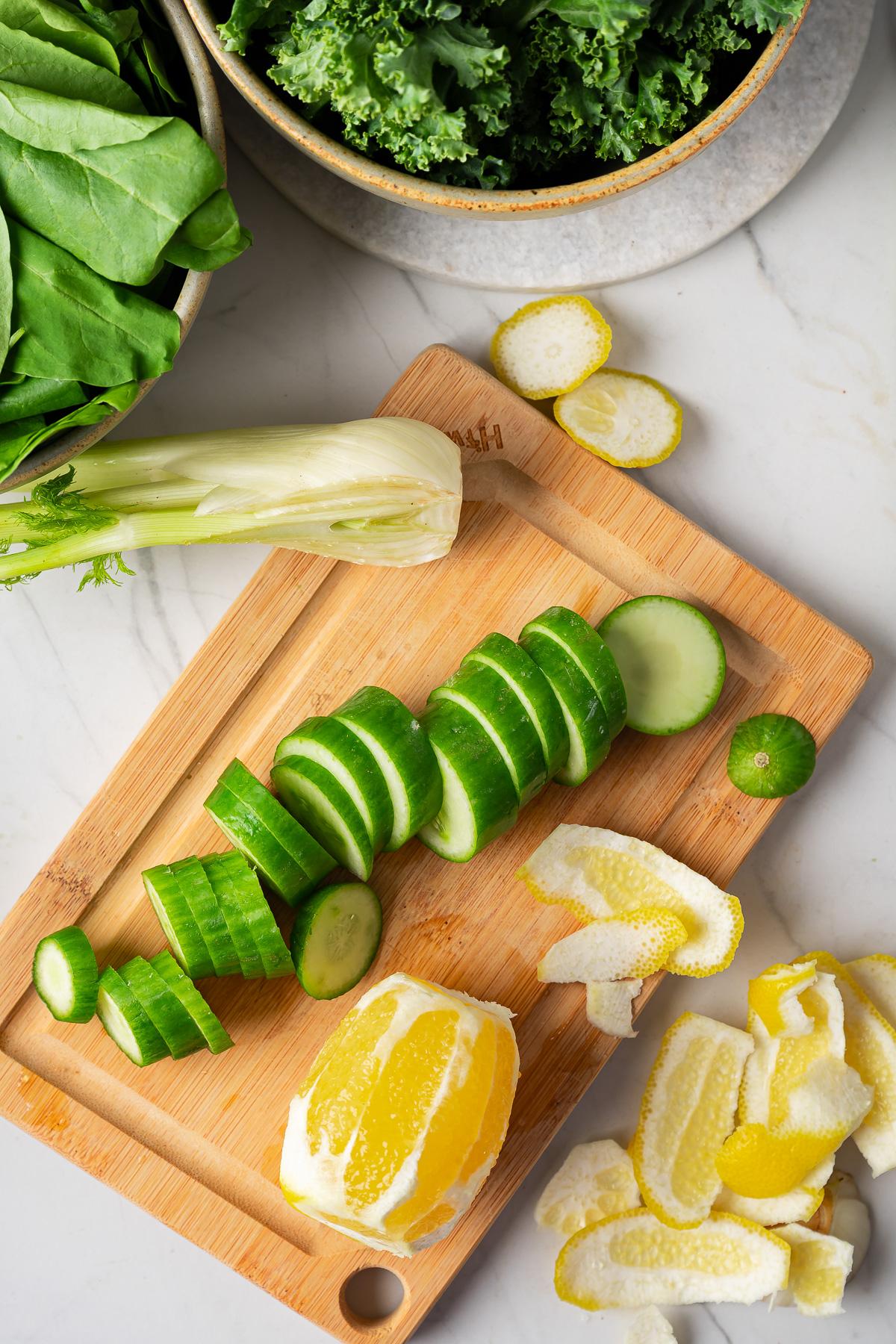 a close-up shot of the ingredients – apple slices, ginger root, spinach leaves, cucumber chunks, and celery sticks – arranged artfully on a wooden cutting board