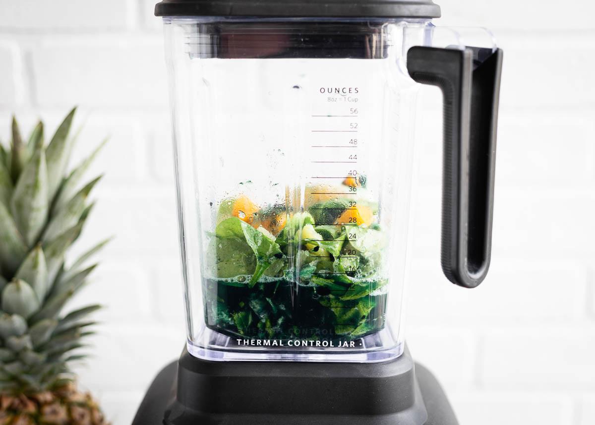 close-up of a blender making a spirulina smoothie with visible ingredients