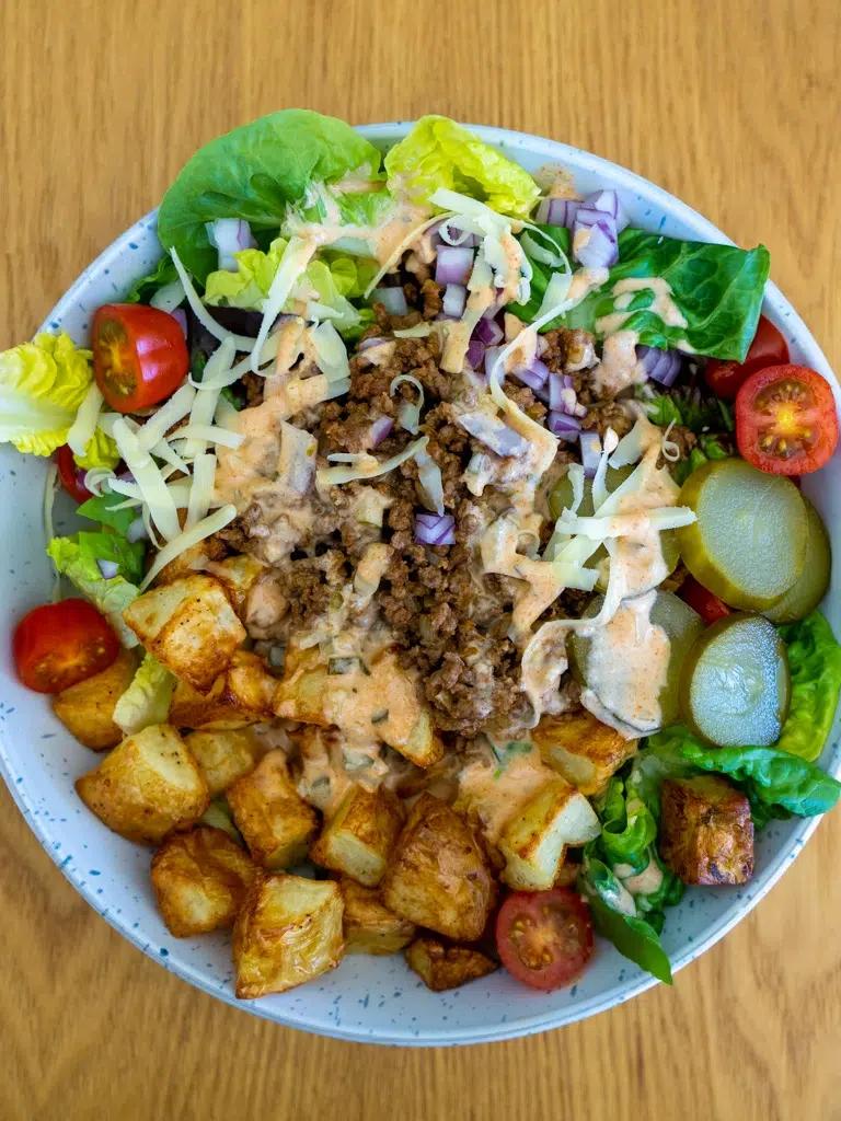 ingredients being combined in a large bowl to form burgers