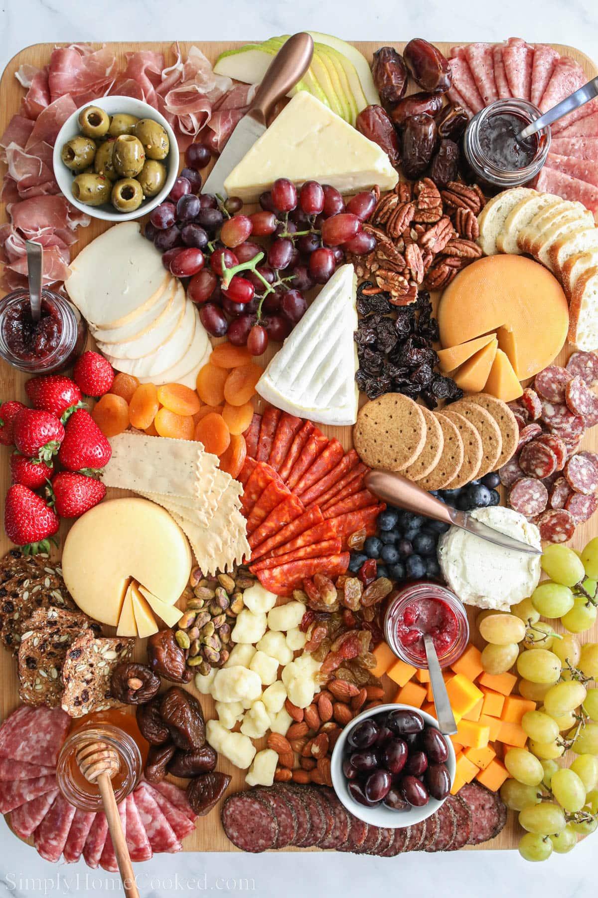 Smoked cheese board with various cheeses, fruits, nuts, and crackers