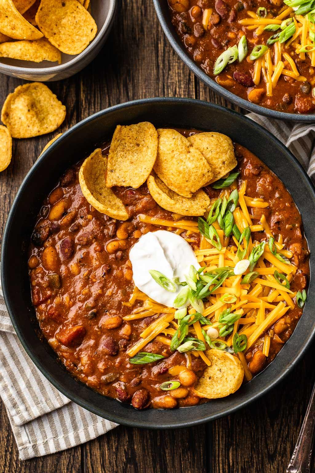 bowl of five-bean chili with cornbread and vegan sour cream