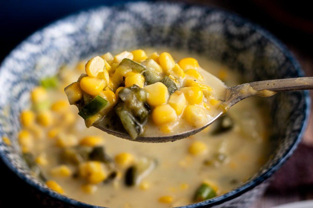 Close-up shot of a pot of spicy corn chowder simmering on the stovetop