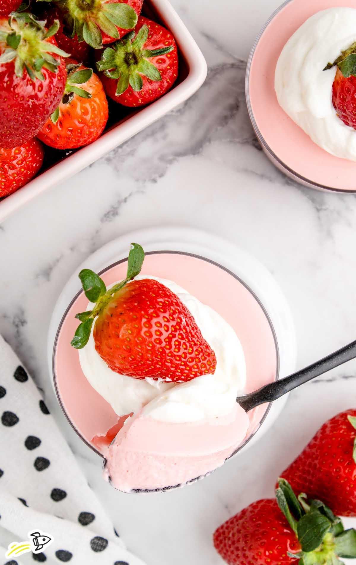 Overhead shot of several glasses of strawberry mousse garnished with fresh strawberries
