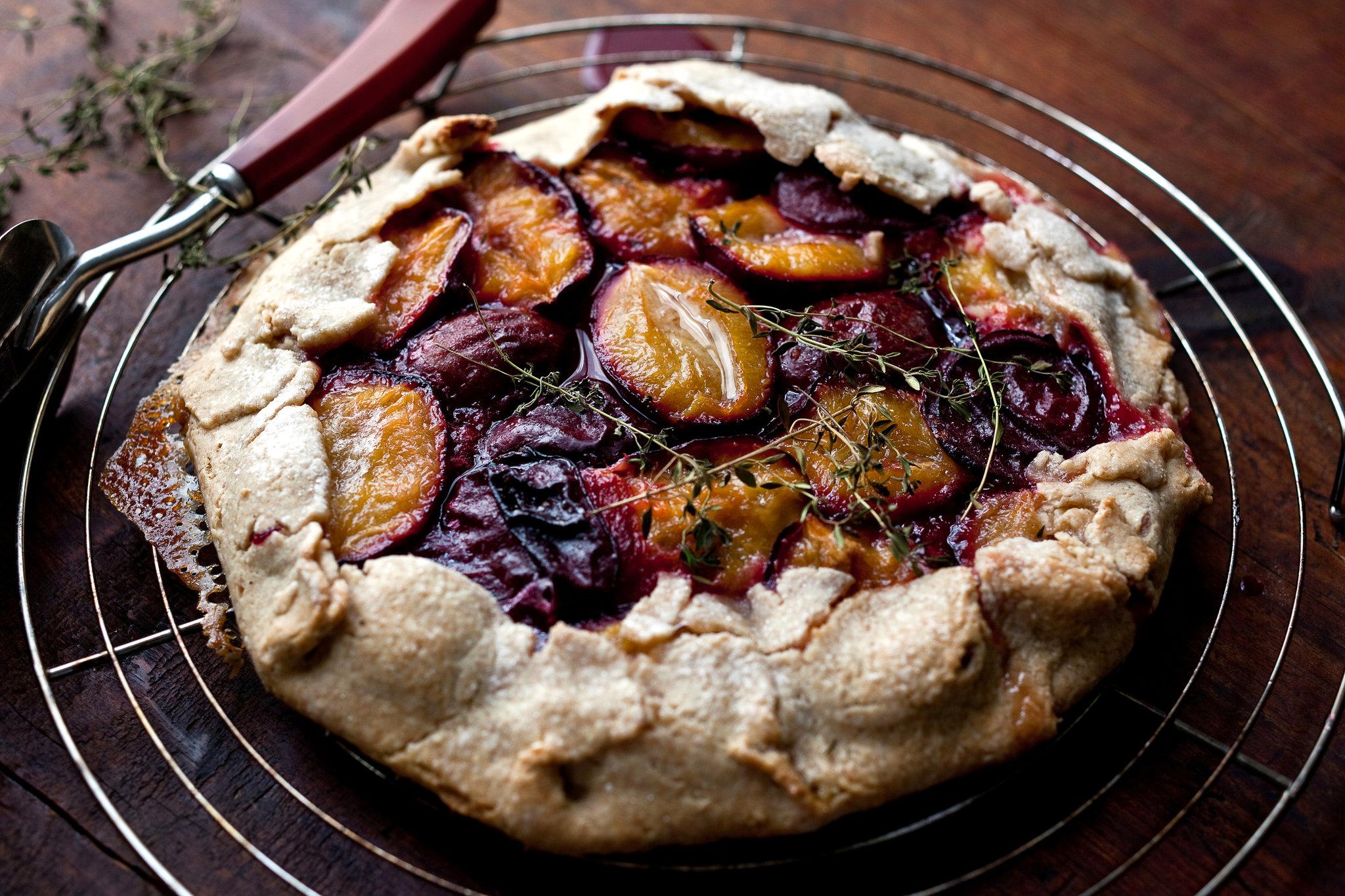 rustic thyme plum tart on a wooden table