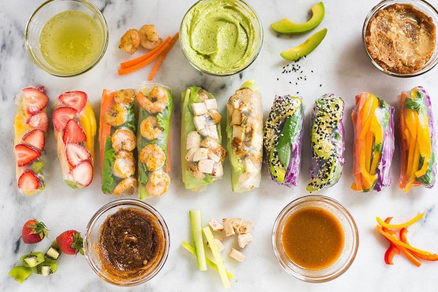 Overhead shot of assembled spring rolls with dipping sauce, featuring a vibrant array of colors and textures