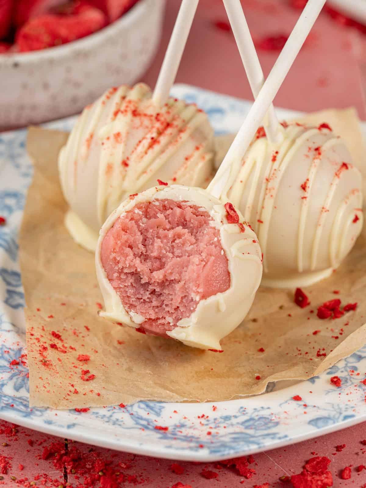 hands holding a tray of strawberry lemonade cake pops