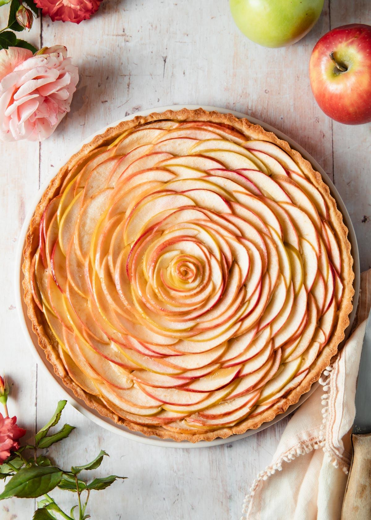 a close-up of the intricate apple rose pattern on the tart, highlighting the textures and colors