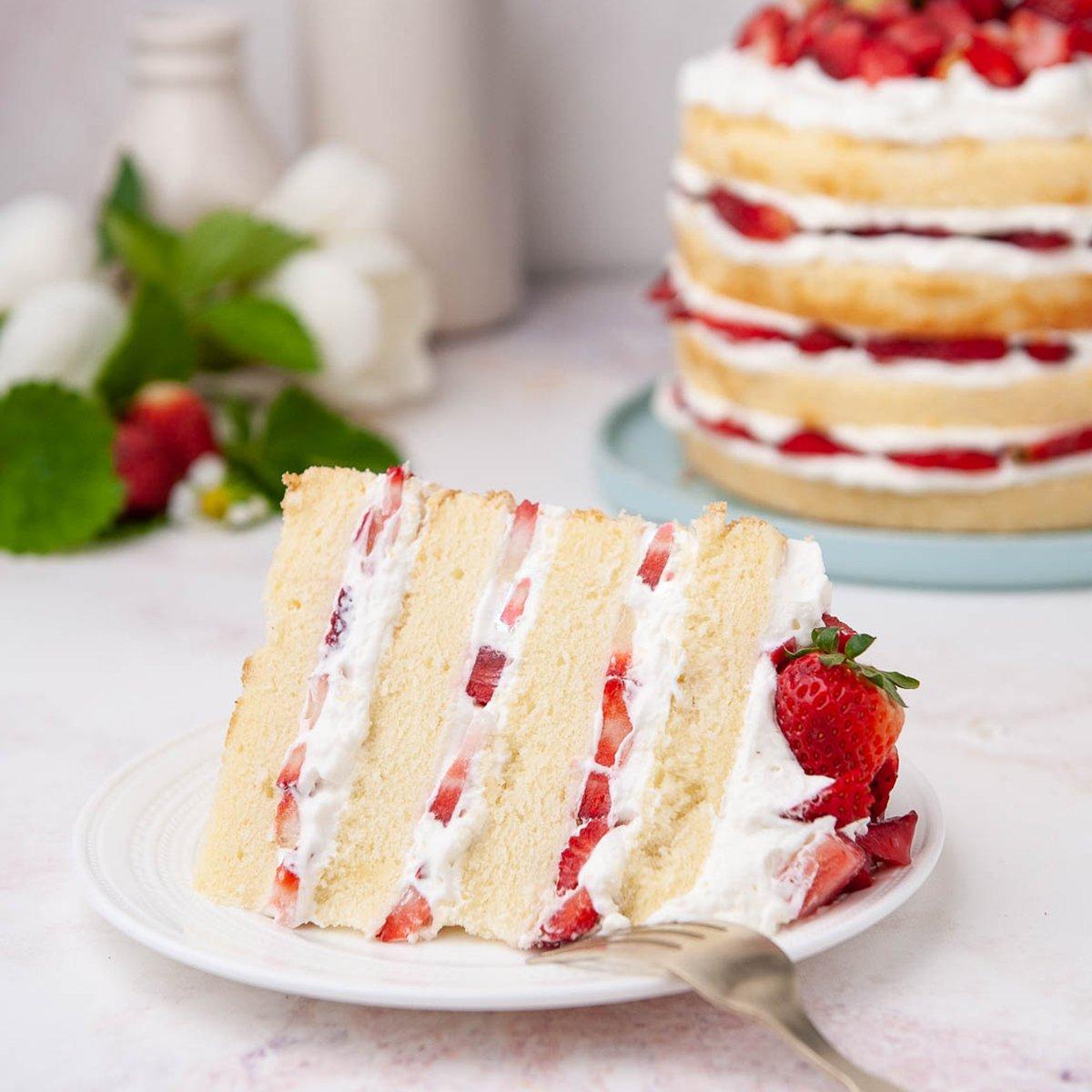 layered strawberry shortcake cake with fresh strawberries and whipped cream