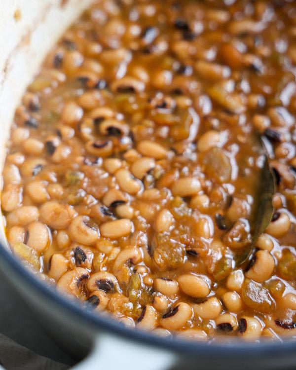 A close-up of a pot of black-eyed peas simmering on a stovetop