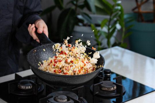 Close-up shot of Dutch stamppot fried rice being stir-fried in a wok