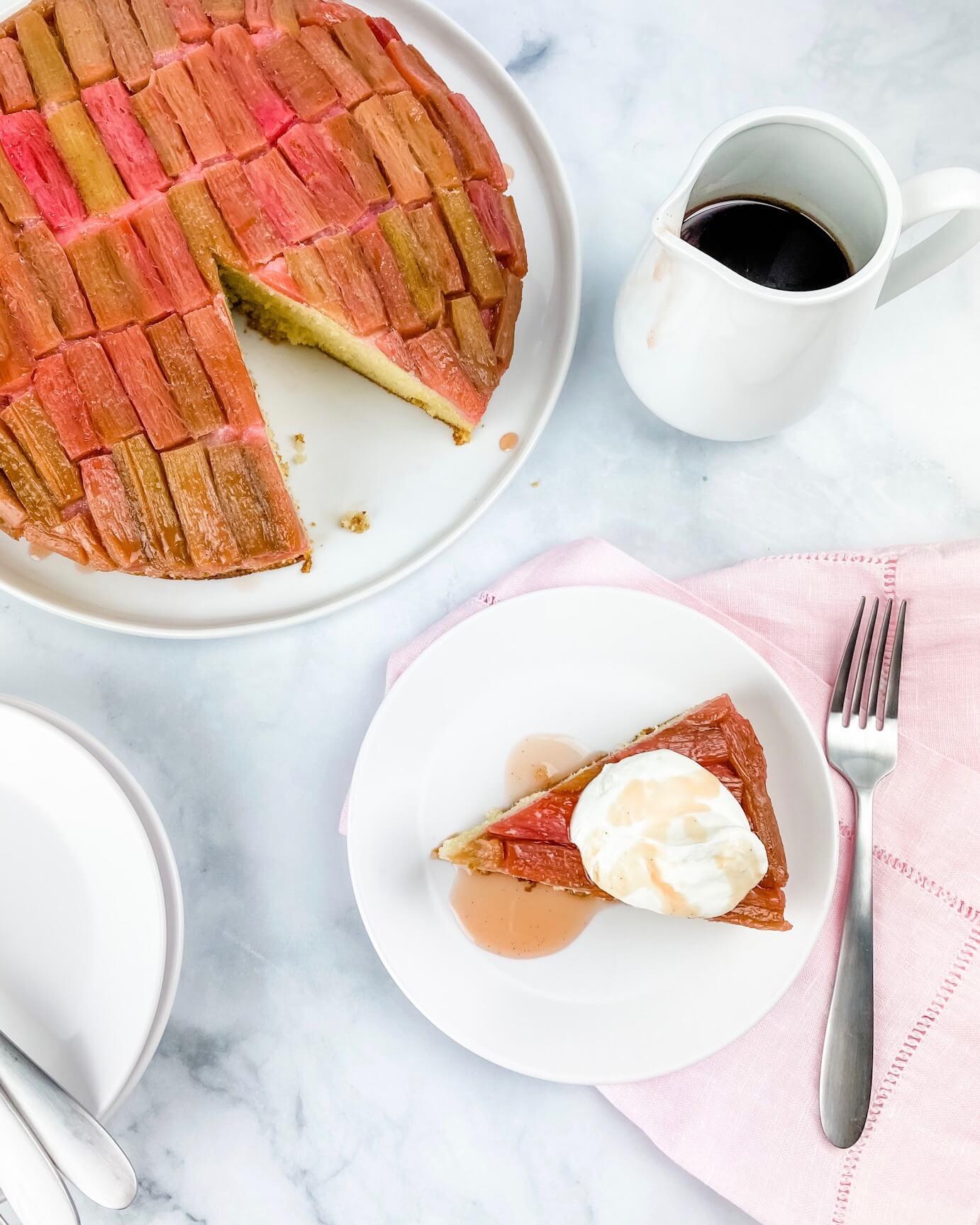 close-up shot of a slice of rhubarb cake showing the texture and layers, served with a cup of tea