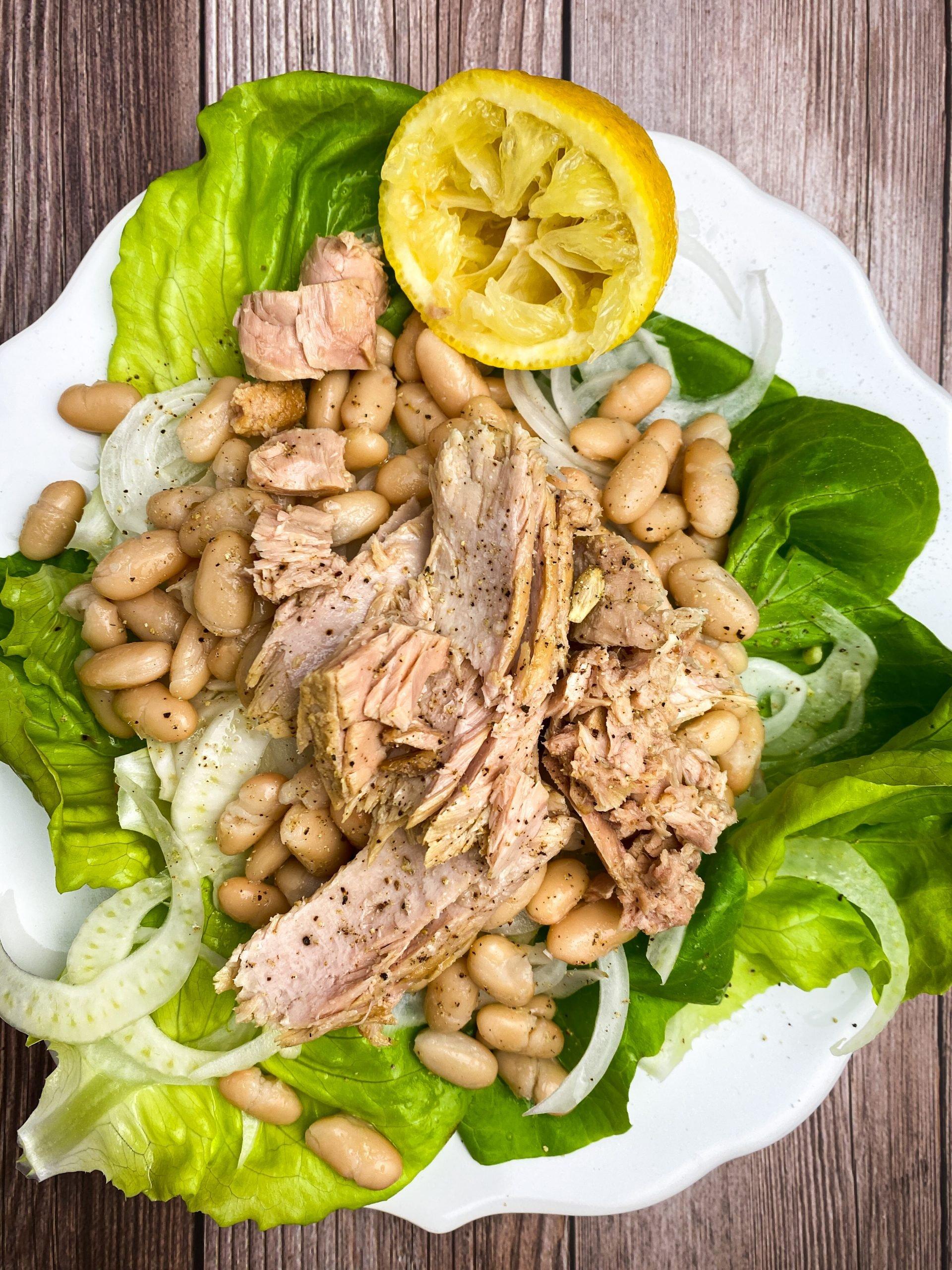 white bean and tuna salad plated with lemon wedges and crusty bread