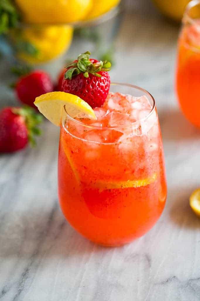 preparation of homemade strawberry lemonade with fresh strawberries and lemons