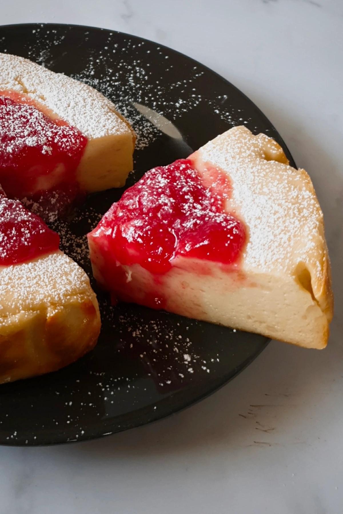 a hand sprinkling powdered sugar on a yogurt cake