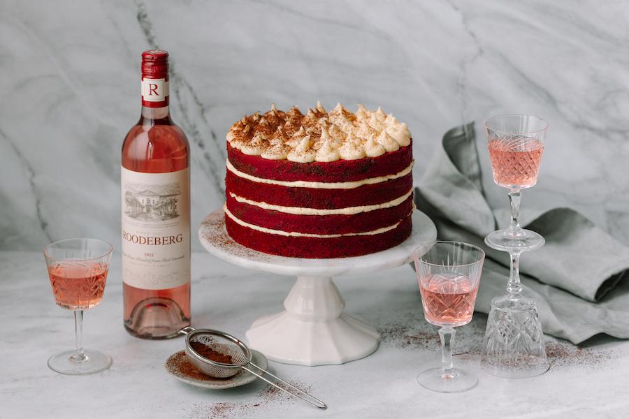 Slices of Crimson Velvet Sunrise Cake stacked, with cream cheese frosting dripping down the sides