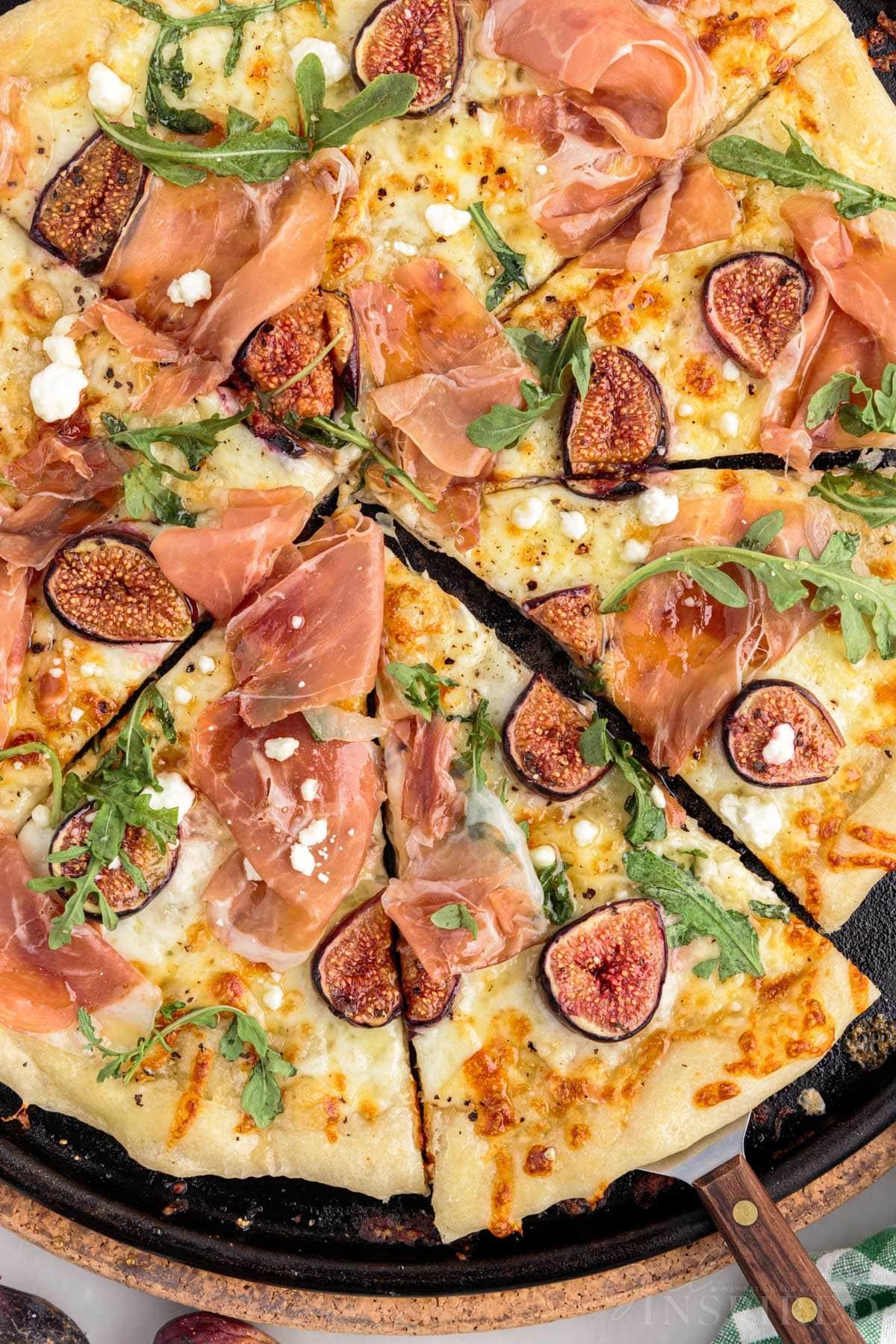 Overhead shot of a perfectly baked fig and prosciutto pizza