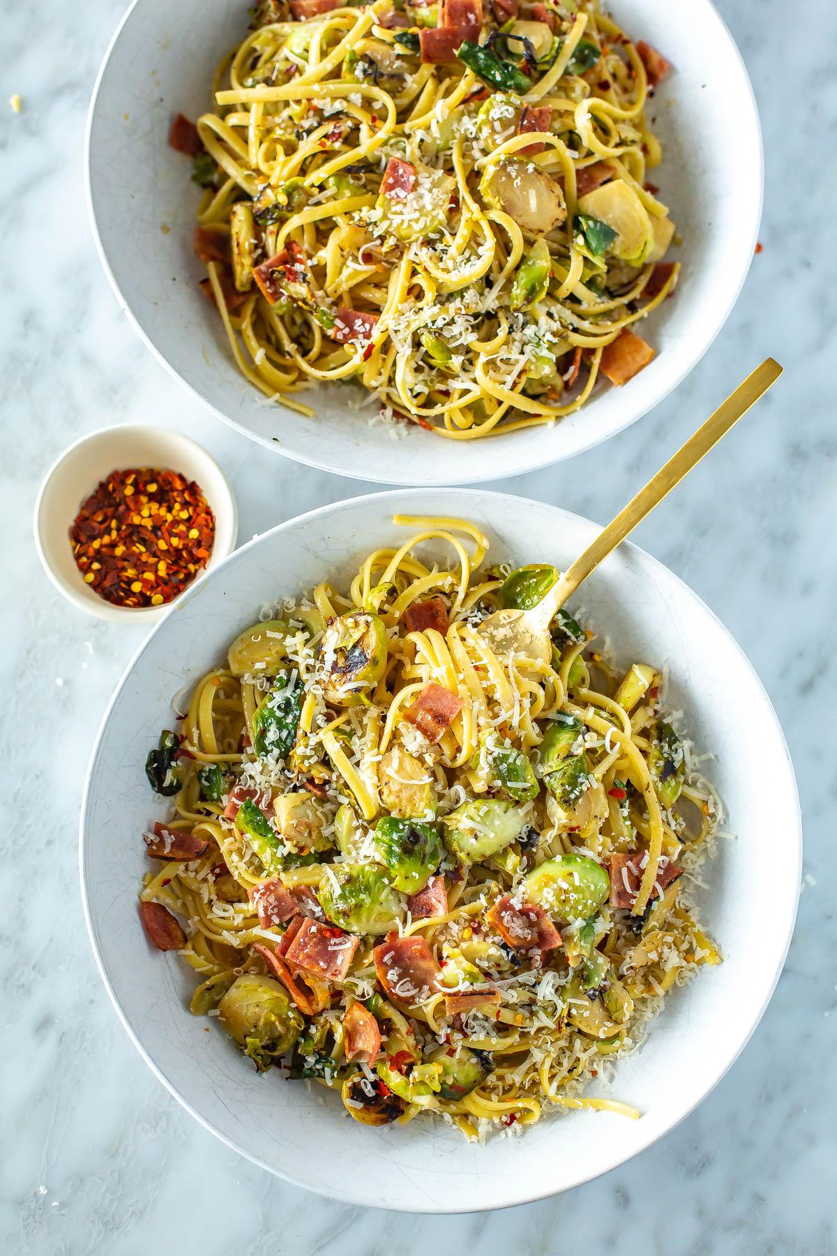 a bowl of bacon and brussels sprouts zucchini noodle bowl with parmesan cheese