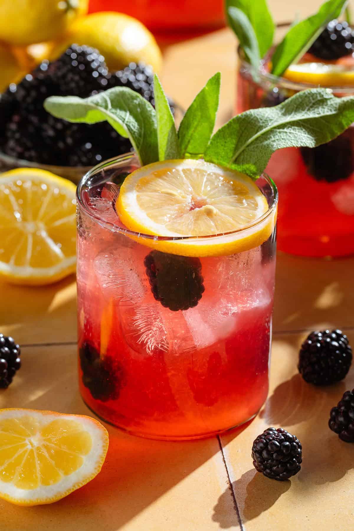pitcher of blackberry sage lemonade with lemon slices and fresh blackberries