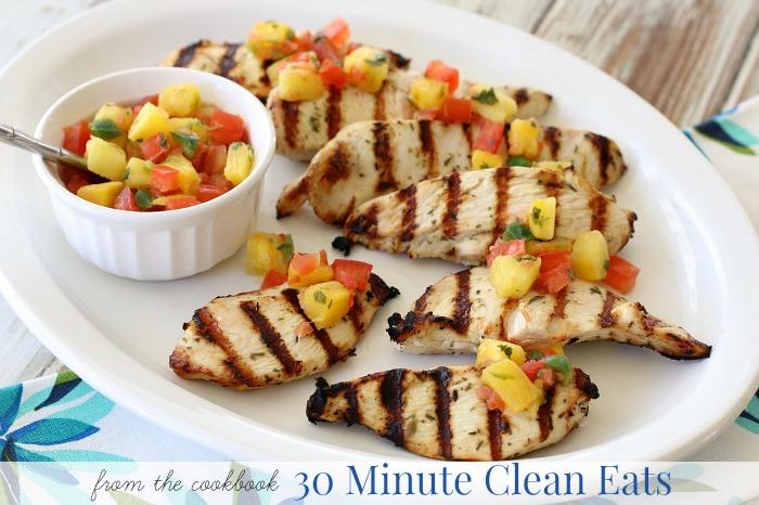 Grilled pineapple salsa chicken breasts on a wooden platter