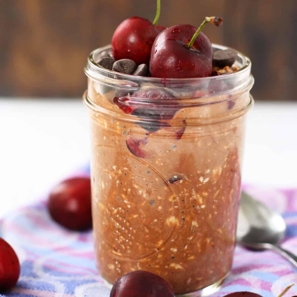 overhead view of a table with several jars of cherry chocolate overnight oats