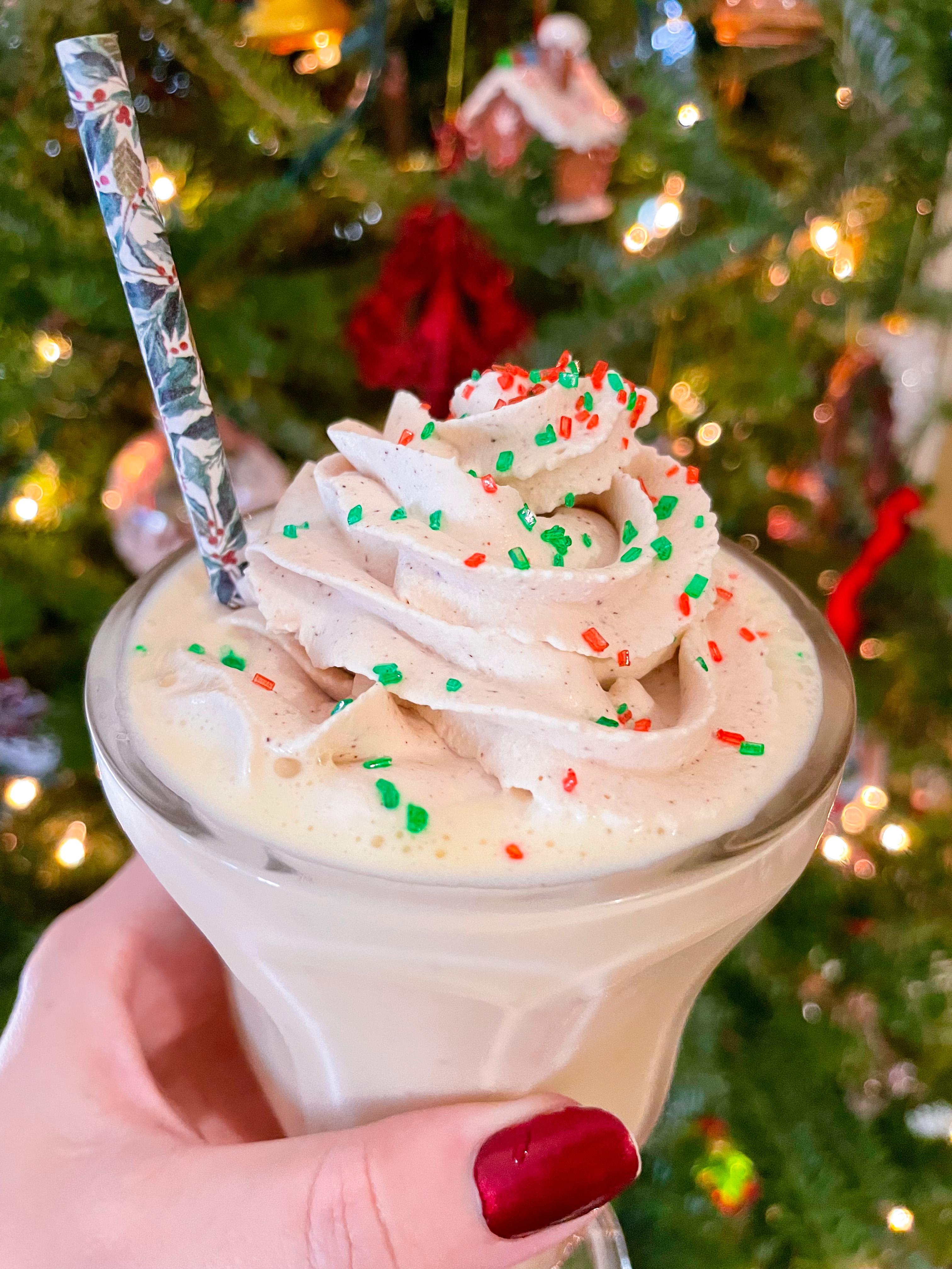 several eggnog milkshakes on a festive holiday table