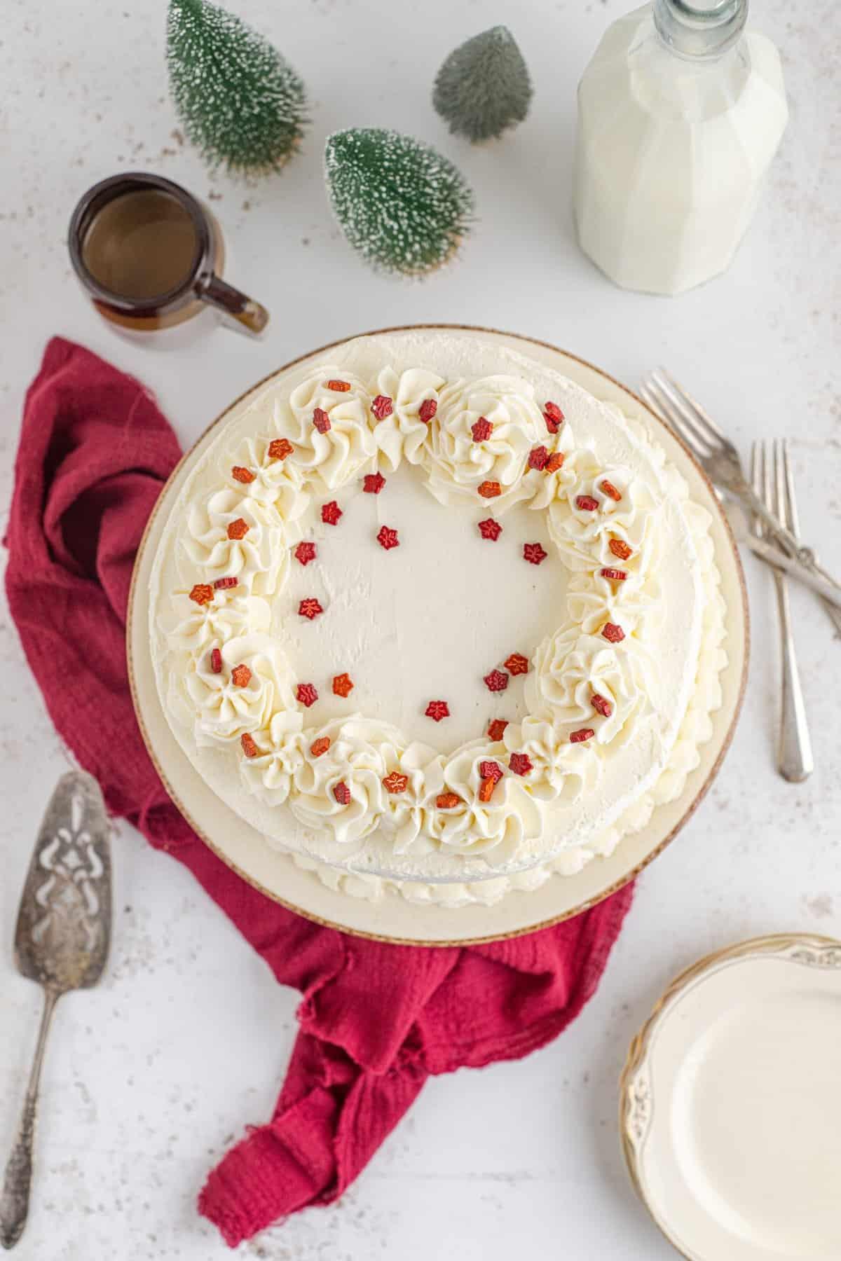 Overhead shot of a slice of vanilla birthday cake with maple syrup frosting on a plate