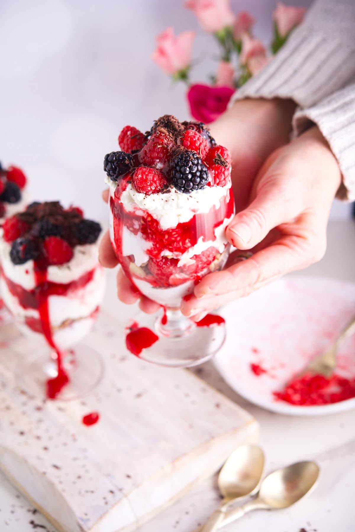 layered raspberries and cream yogurt parfait in tall glass
