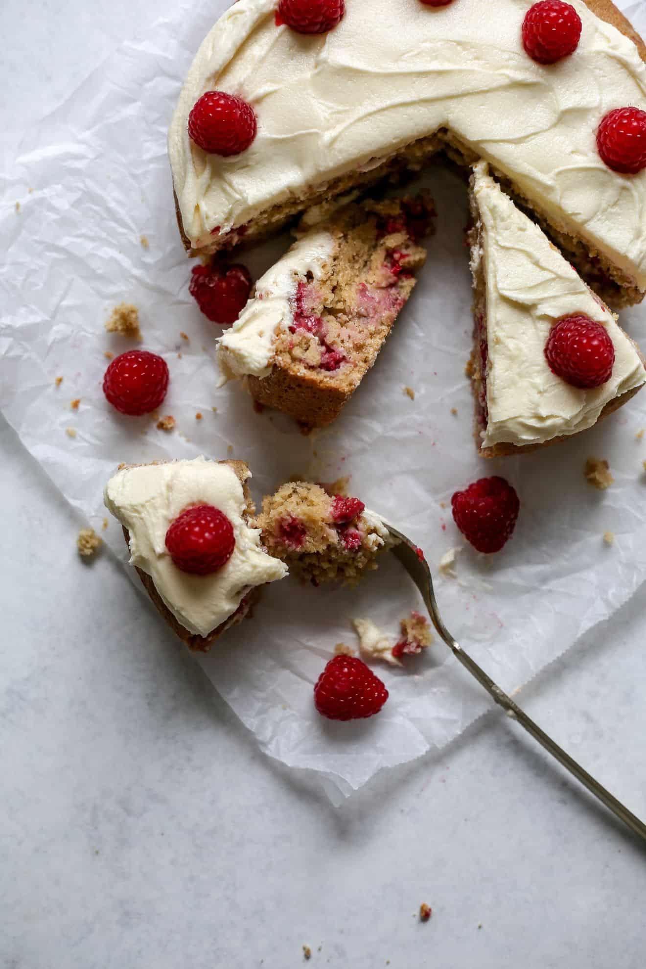 overhead shot of summer raspberry rose cake with a slice being taken