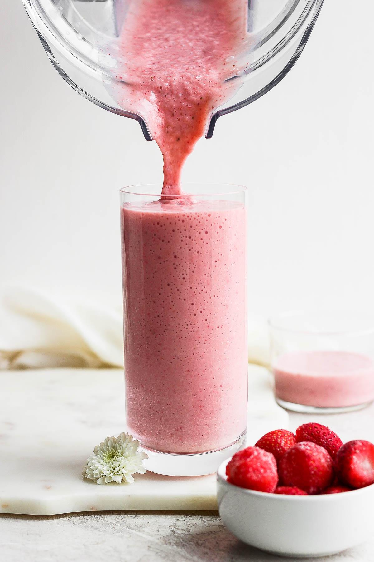 strawberry banana smoothie being poured into a glass
