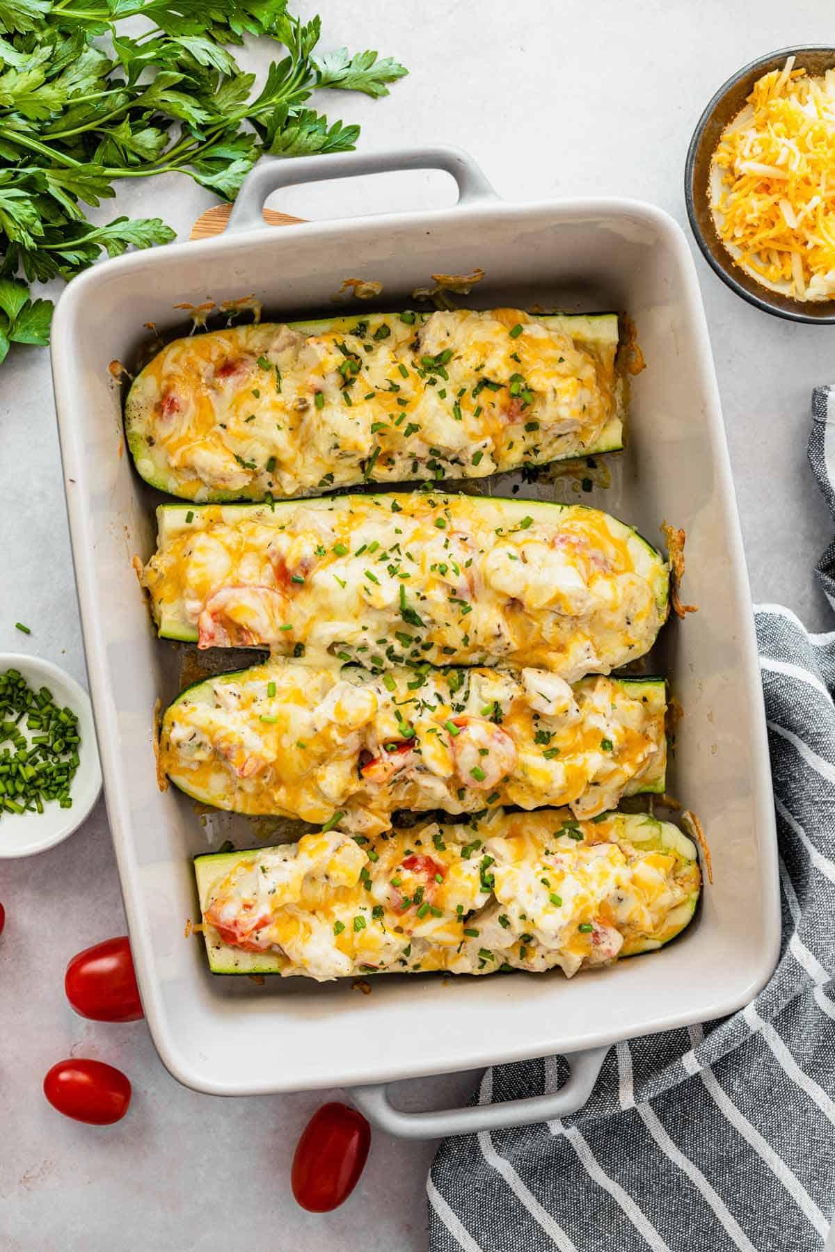 Overhead shot of a baking dish filled with lemon herb chicken stuffed zucchini boats ready to go into the oven
