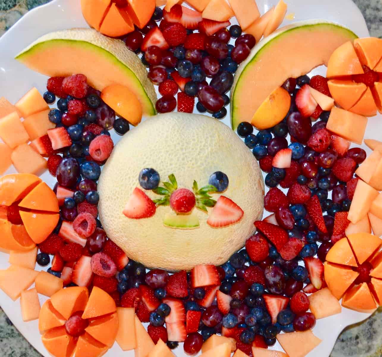 Child's face lighting up looking at a fruit platter