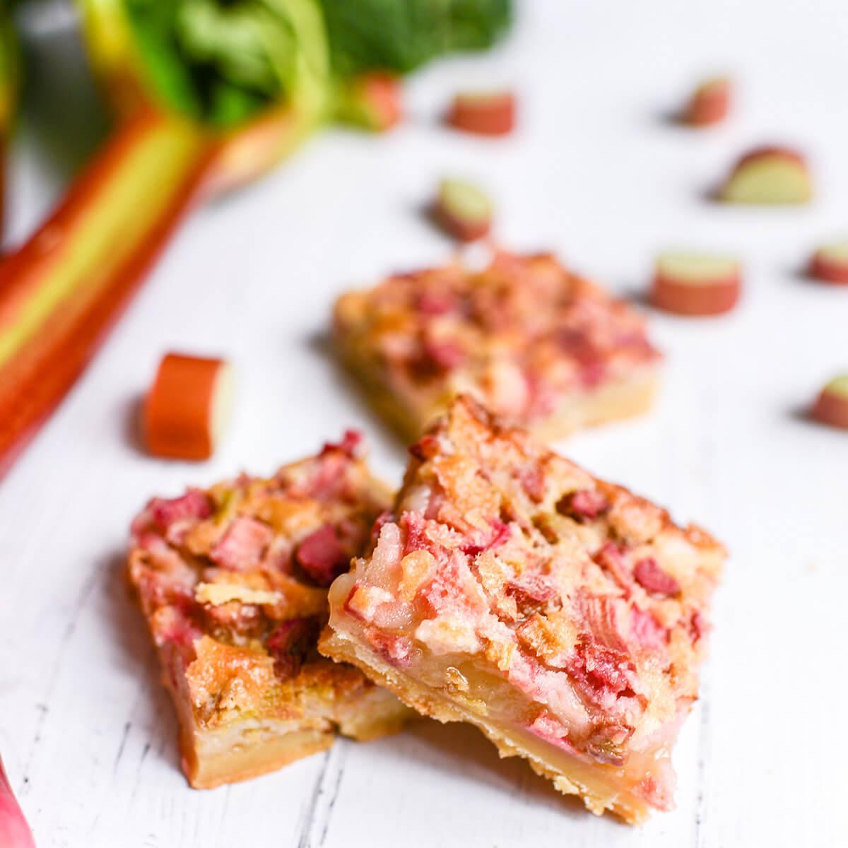 A slice of whipped rhubarb custard bar being lifted from the pan