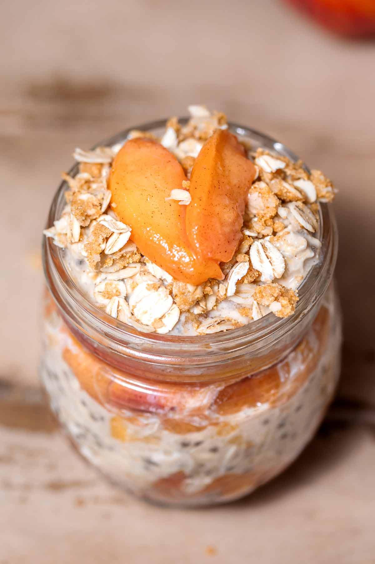 close up of peach cobbler overnight oats in a glass jar