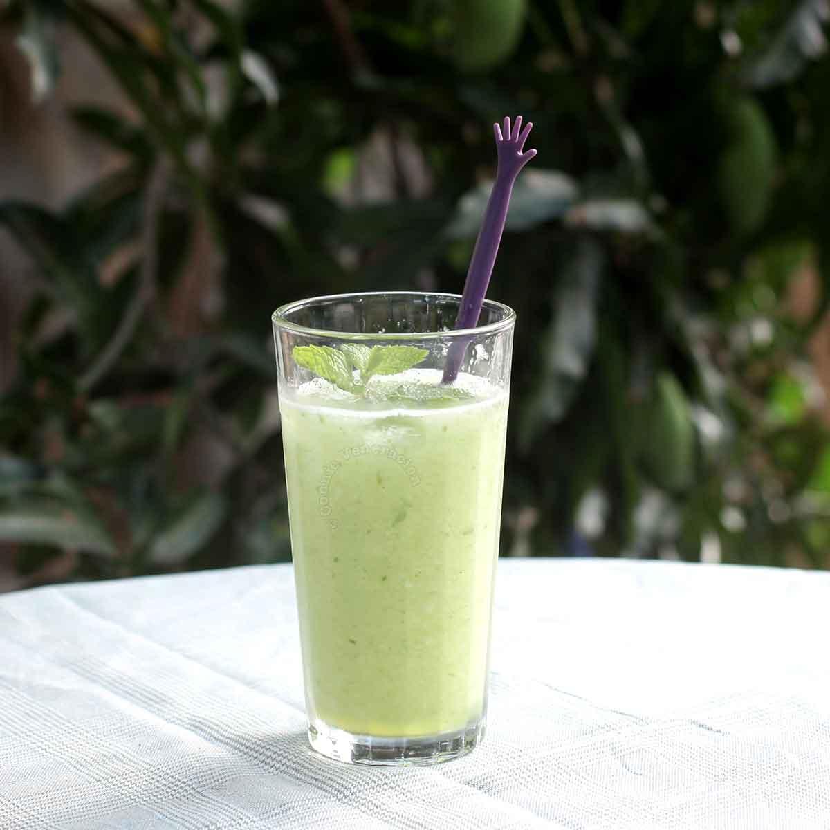cucumber and coconut smoothie in a glass, garnished with mint