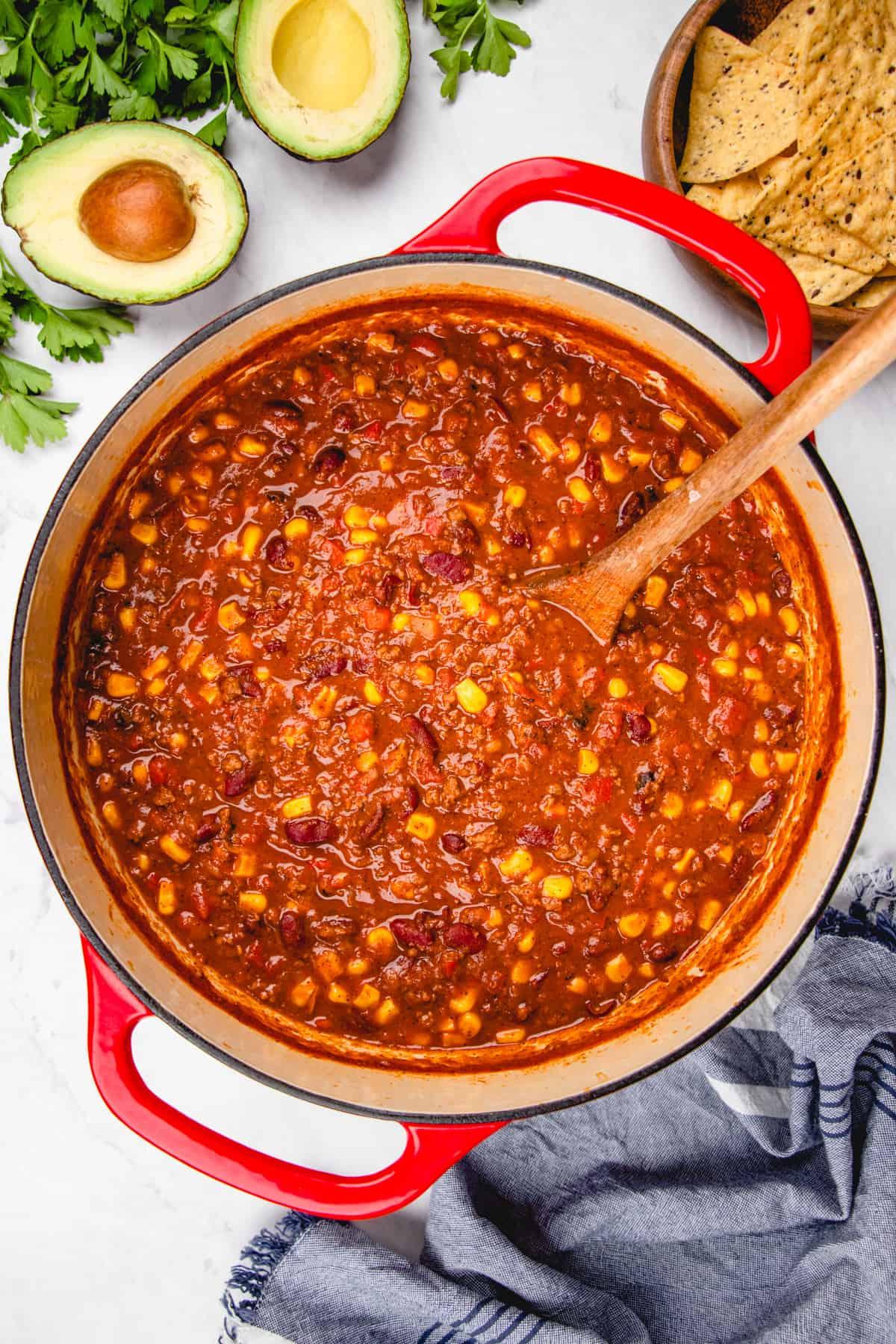 close-up shot of lavender and rosemary chili being stirred in a dutch oven, showcasing the rich colors and textures of the ingredients