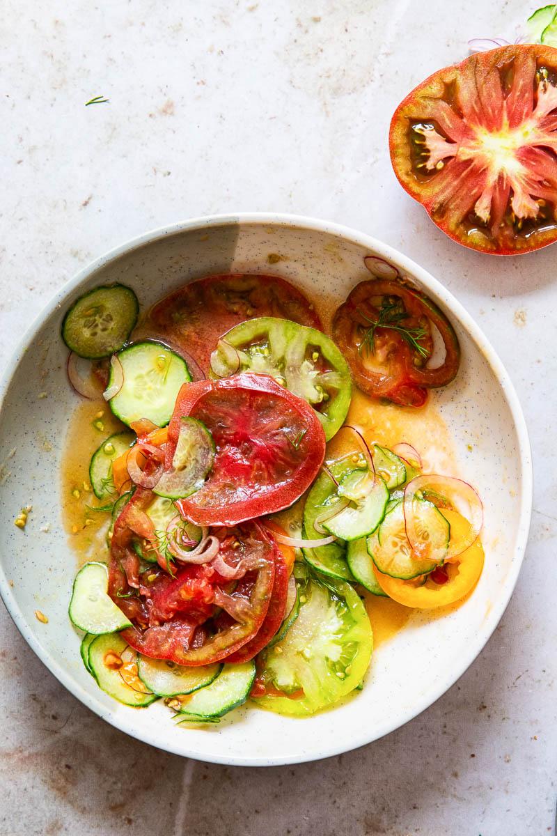overhead shot of heirloom tomato and cucumber salad in a rustic bowl