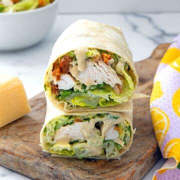 Close-up shot of a perfectly grilled chicken caesar wrap, cut in half to show the filling