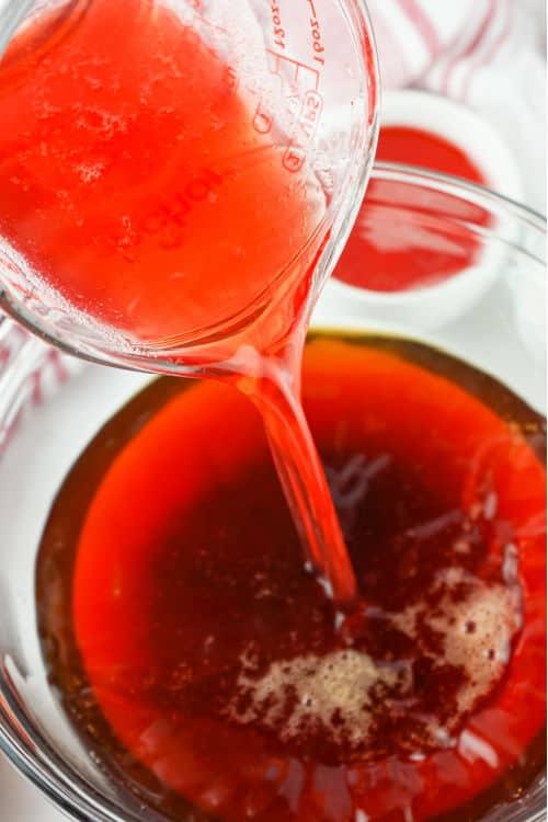 close-up of homemade strawberry syrup being poured into iced tea