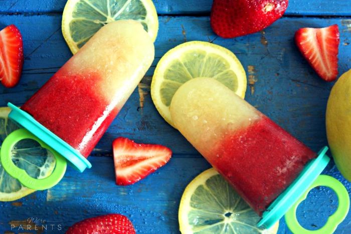 person holding strawberry lemonade popsicle in summer