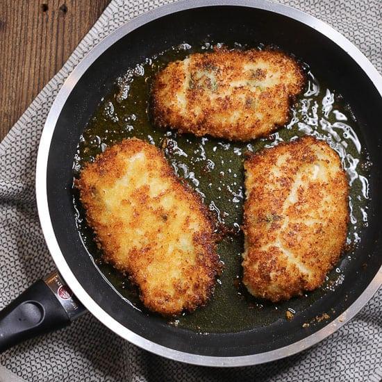 close-up shot of breaded chicken being seared in a skillet