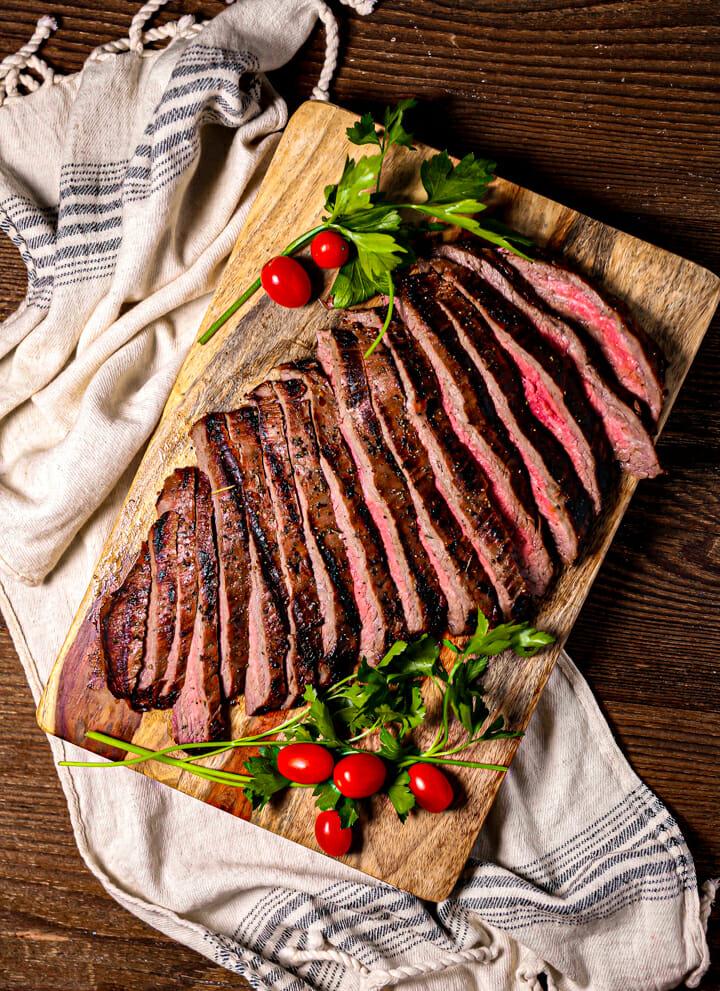 grilled flank steak sliced on a cutting board