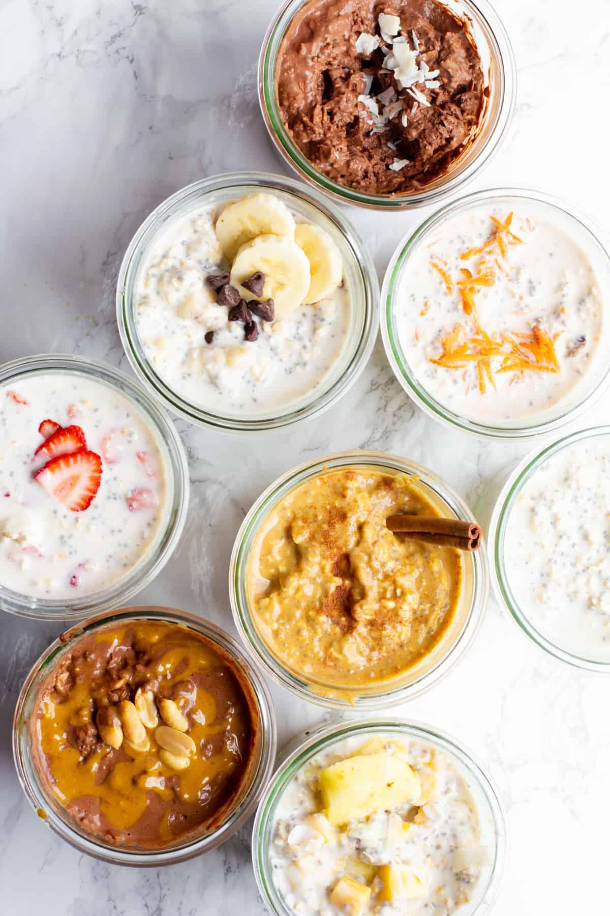 overhead shot of several jars of tropical sunrise overnight oats with different toppings, showcasing the versatility of the recipe