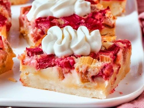a hand reaching for spiced rhubarb custard bar