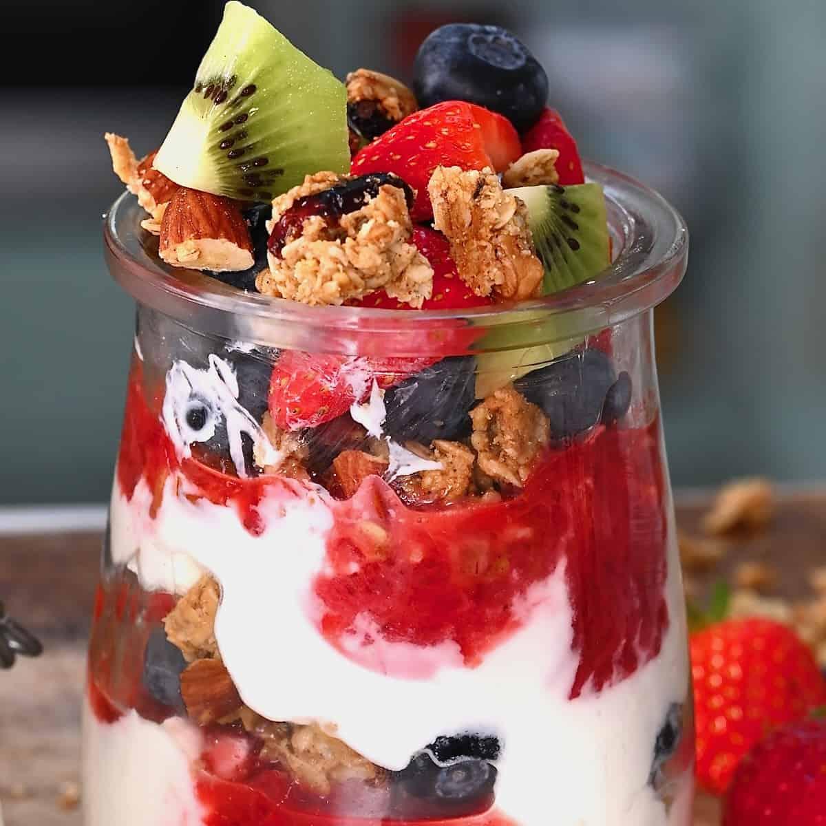 assembling ginger peach yogurt parfait in a glass jar