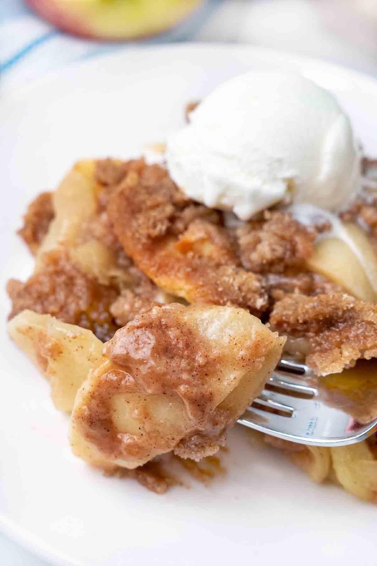 Close-up shot of Apple Brown Betty being scooped from a baking dish, steam rising