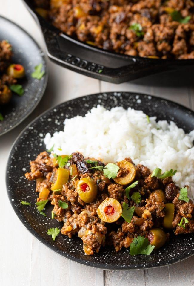 Cuban ground beef picadillo served with white rice, garnished with olives and cilantro